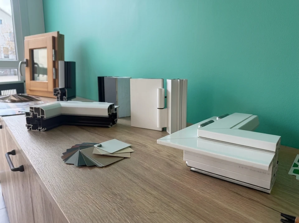 Showroom de menuiserie, comptoir en bois avec échantillons de profilés aluminium et PVC pour fenêtres et portes