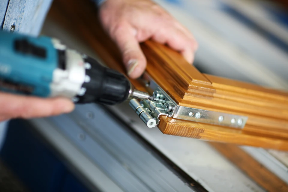 Showroom de menuiseries avec présentoirs en bois clair sur carrelage anthracite